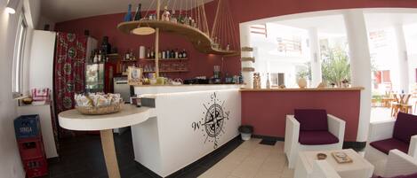 Una cocina moderna con una isla blanca, una lámpara colgante y una pared de acento roja.