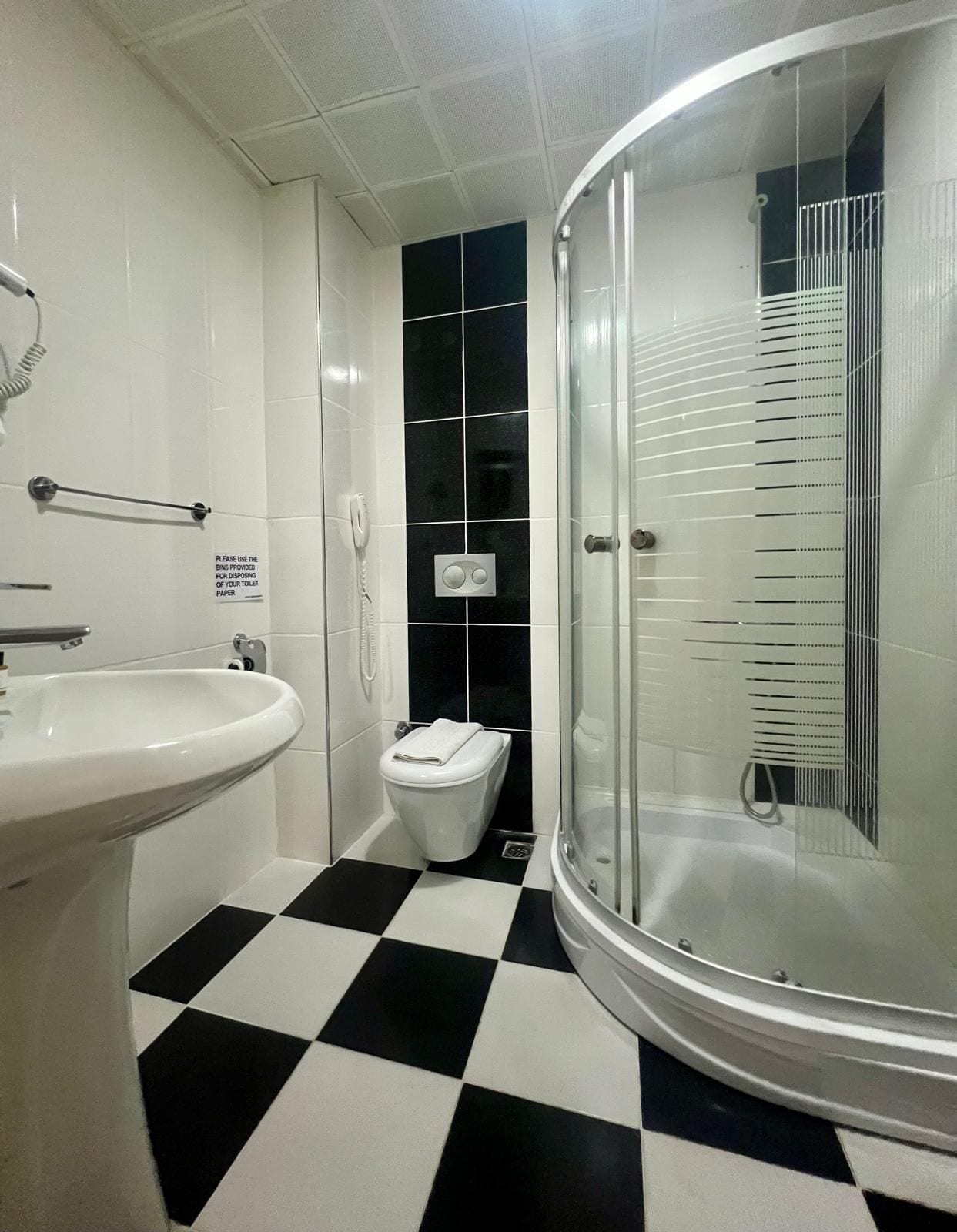 A bathroom with a white sink, a toilet, and a glass-enclosed shower.