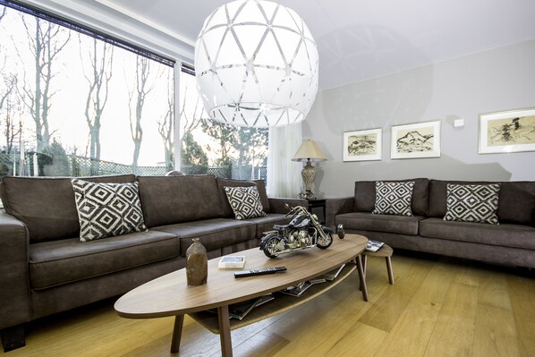 A modern living room with two sofas, a coffee table, and a motorcycle model.