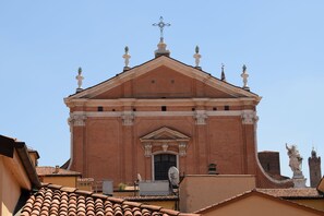 A building with a symmetrical facade, a central entrance, and a cross at the top. - Cristina Rossi Bed and  Breakfast (Bologna)
