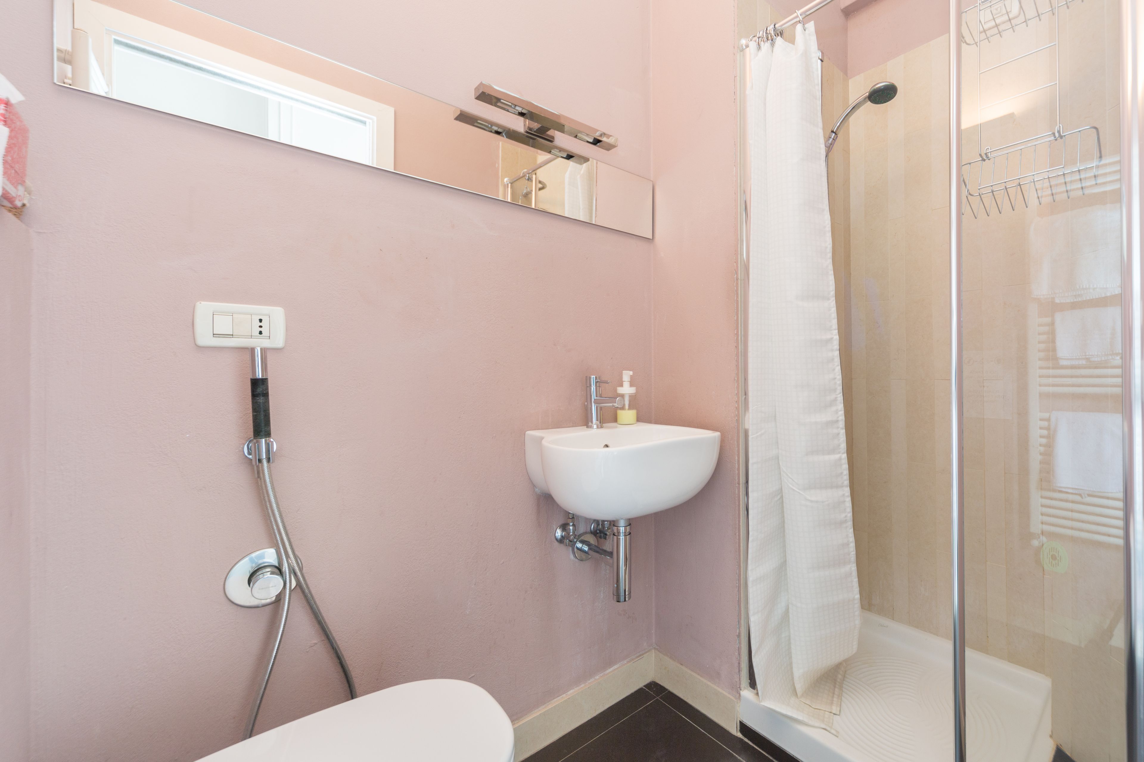 Un bagno con doccia, lavabo e water.