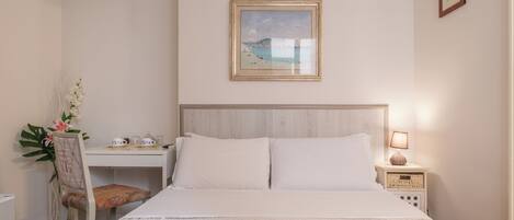 Una habitación de hotel ordenada con cama, escritorio y silla.