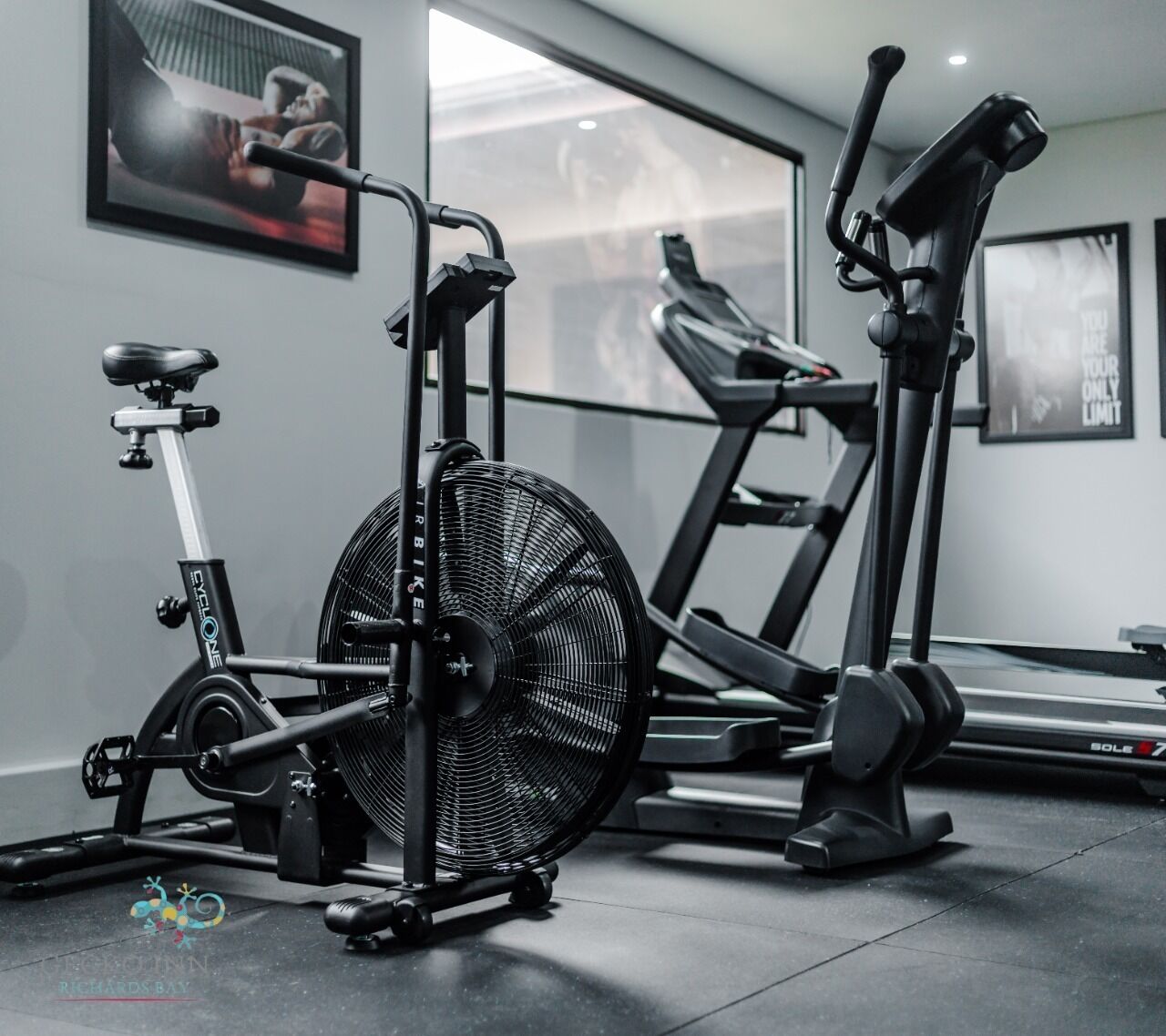 Un gimnasio con bicicleta estática, elíptica y cinta de correr.