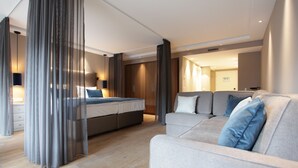 A modern hotel room with a bed, a sofa, and a desk. - Hotel Aurelia (Aldingen)
