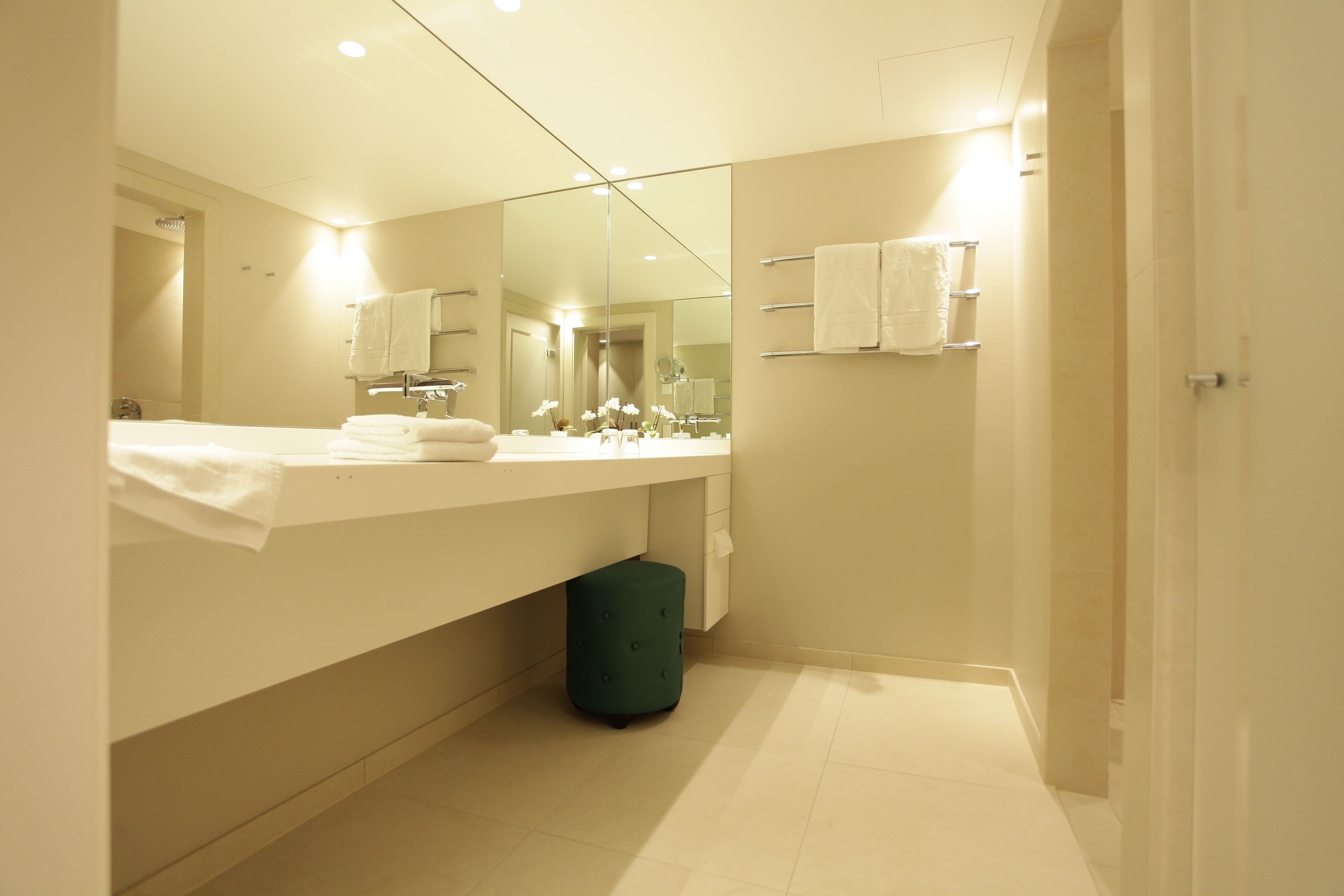 A modern bathroom with a large mirror, a vanity with a sink, and a toilet.