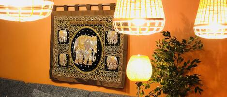 A cozy living area with a sofa, a dining table with placemats, and decorative lamps.