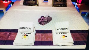 A hotel room with a bed, pillows, and towels with 'Kookhai' branding. - B&B Kookhai (Kluisbergen)