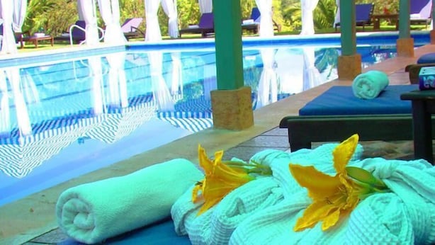 A poolside area with lounge chairs, towels, and a spa sign. - Hotel Iguaque Campestre Spa & Ecolodge (Villa de Leyva)