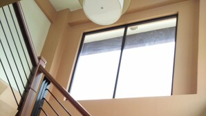 A multi-level interior with a staircase, large windows, and a ceiling light fixture. - Belize Tagaytay (Tagaytay)