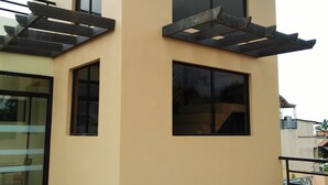 A modern building with a flat roof, large windows, and a balcony with a metal railing. - Belize Tagaytay (Tagaytay)
