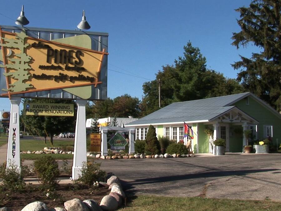 Un bâtiment doté d’un toit végétalisé et d’une enseigne publicitaire annonçant des travaux de rénovation des chambres.