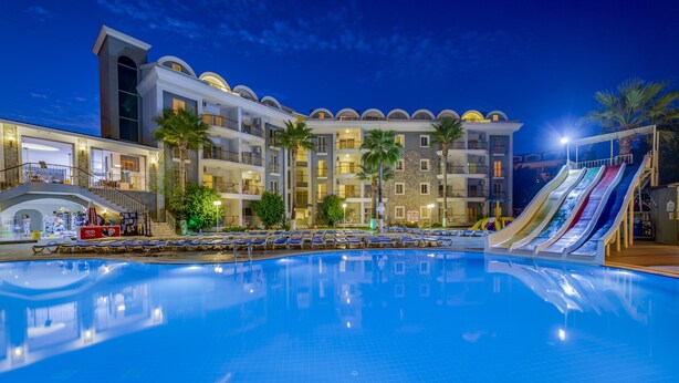 A hotel with a swimming pool, multiple balconies, and a water slide.
