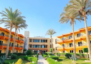 A hotel with multiple floors, a central courtyard with palm trees, and a clear sky. - Retal View El Sokhna Hotel & Resort (Ain Sokhna)