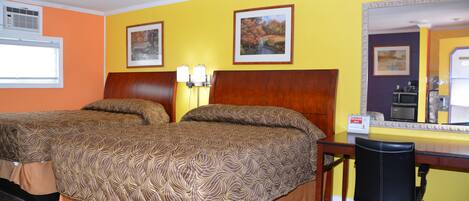 A hotel room with two beds, a desk, and a chair.
