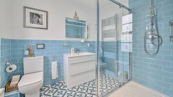 Un baño con inodoro, lavamanos y ducha.