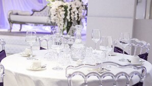 A round table set with clear glassware and white tablecloth, surrounded by ornate chairs. - KT Hotels (Ouled Yaich)