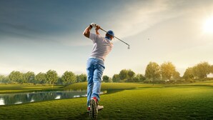 Un campo da golf con uno specchio d'acqua e alberi sullo sfondo.