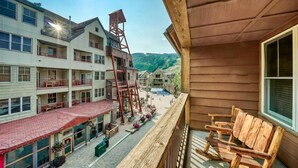 A multi-story hotel with a red-roofed ground floor restaurant, outdoor seating, and a wooden balcony with chairs. - Buffalo Lodge 3 Bed 3 Bath (Keystone)