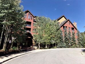 A multi-story building with a red facade, large windows, and a balcony. - Springs 2 Bed 3 Bath Murphy (Keystone)
