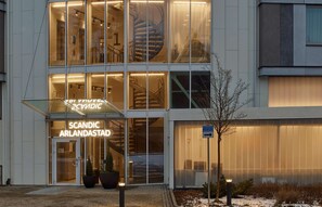 A modern building with a glass facade, a spiral staircase, and a sign reading "SCANDIC ARLANDASTAD." - Scandic Arlandastad (Arlandastad)