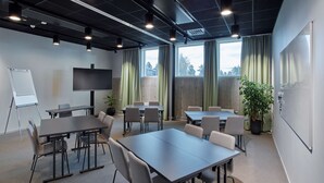 A conference room with a large table, chairs, a whiteboard, and a television.