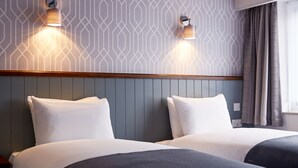A hotel room with two beds, a wooden headboard, and patterned wallpaper. - The Chase Hotel by Greene King Inns (Nuneaton)