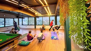 A spacious room with large windows, a pool table, and exercise mats. - Hotel Green View - Behind Pramarth Niketan (Yamkeshwar)