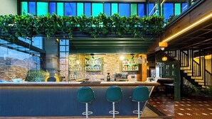 A bar area with a counter, stools, and a view of the outside through large windows. - Hotel Green View - Behind Pramarth Niketan (Yamkeshwar)