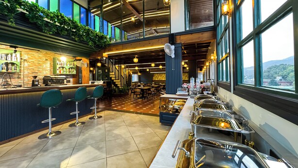 A modern bar area with a counter, bar stools, and a buffet setup with serving dishes. - Hotel Green View - Behind Pramarth Niketan (Yamkeshwar)