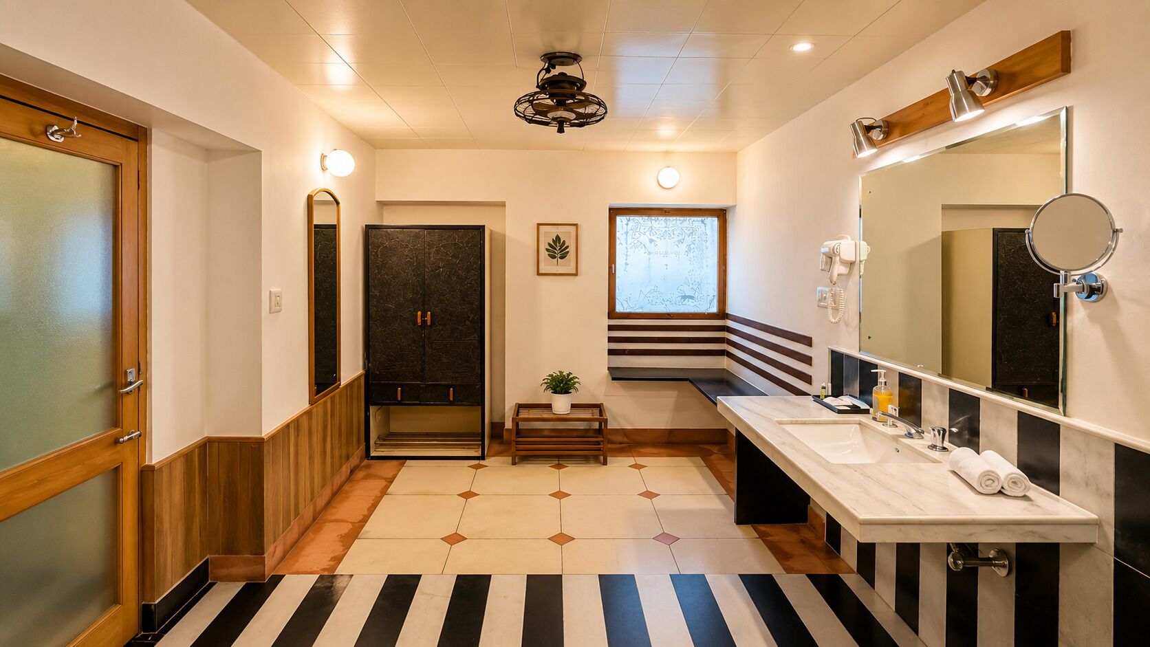 A modern bathroom with a large mirror, two sinks, a vanity, and a wooden bench.