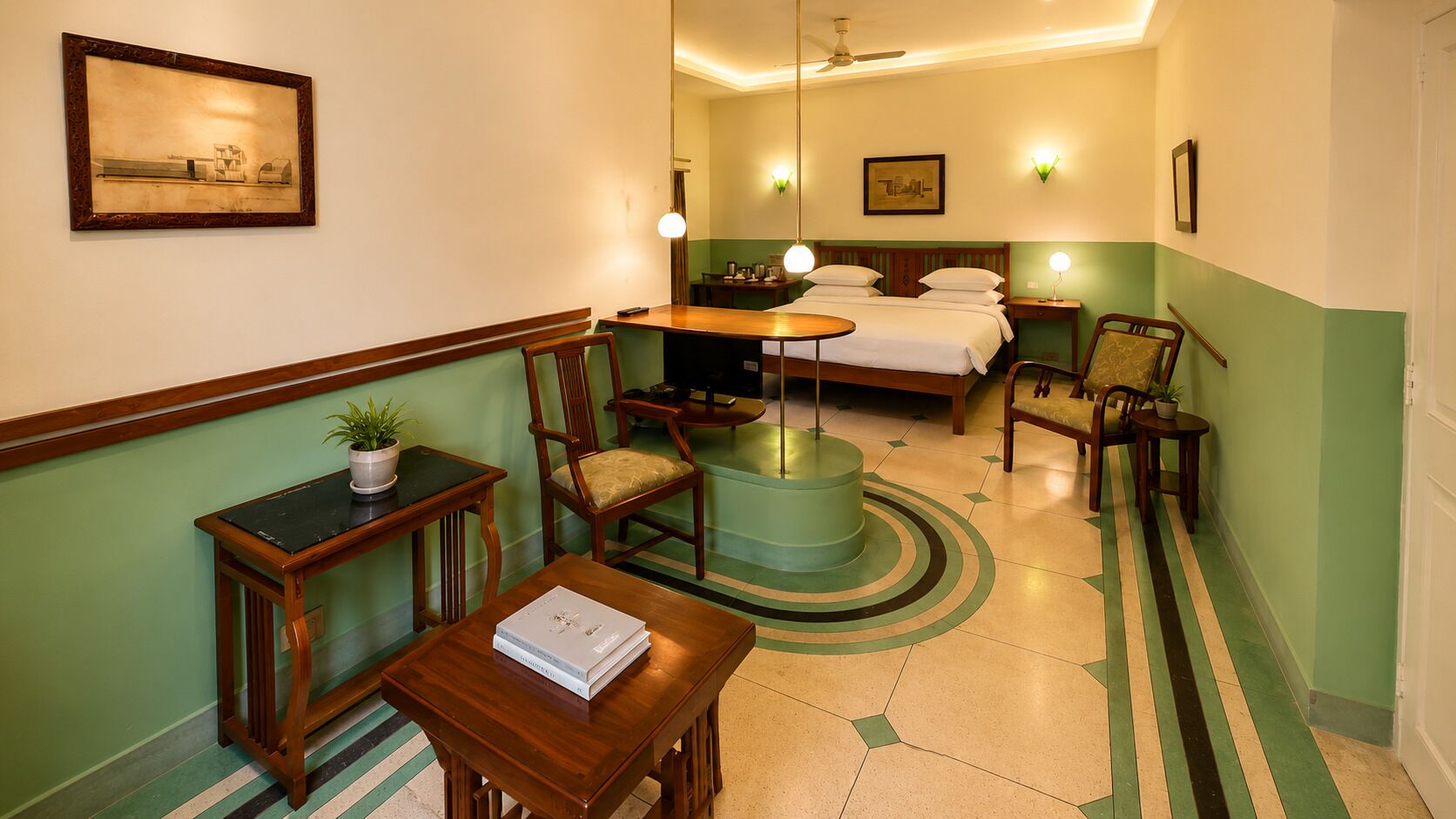Ein Hotelzimmer mit Bett, Schreibtisch, Sessel, Tisch, Lampe, Pflanze und einem Gem älde an der Wand.