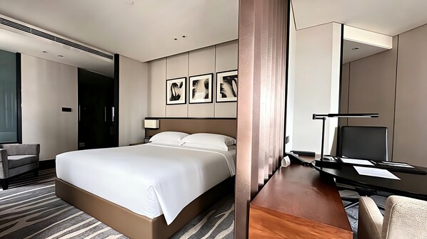 A hotel room with a large bed, a desk with a chair, a TV, and framed artwork on the wall. - InterContinental Shanghai Hongqiao NECC by IHG (Shanghai)