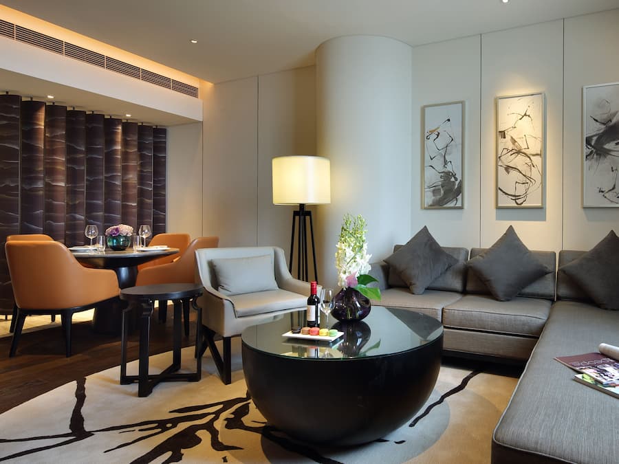 Um saguão moderno de hotel com área de jantar, um sofá e uma mesa de centro.
