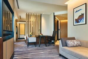 A modern hotel room with a desk, office chair, sofa, and a decorative wall piece. - InterContinental Shanghai Hongqiao NECC by IHG (Shanghai)