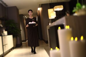 A hotel corridor with a reception area, a plant, and a lit candle display. - InterContinental Shanghai Hongqiao NECC by IHG (Shanghai)