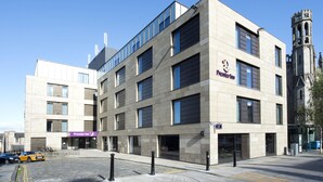 A modern building with a Premier Inn sign, large windows, and a tower structure in the background. - Premier Inn Edinburgh Cc York Place/St James Quarter (Edinburgh)
