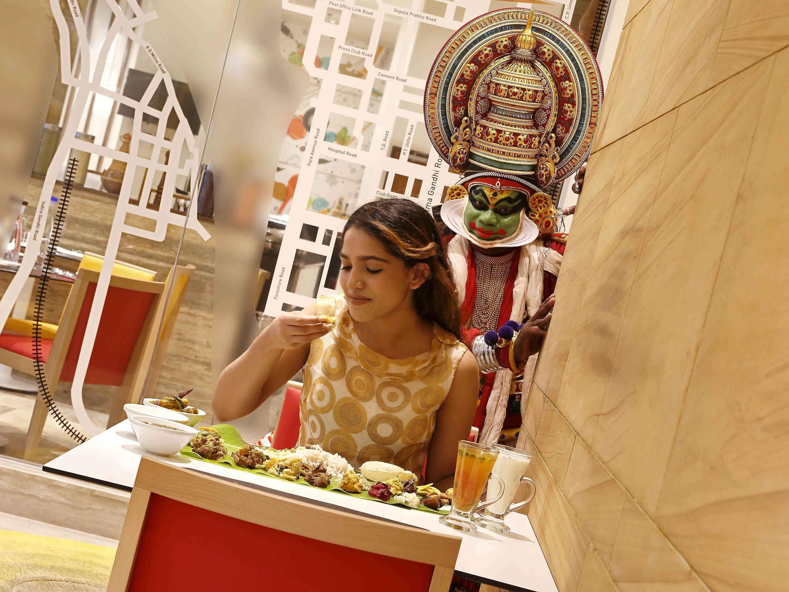 A dining area with a table set for a meal, a decorative wall, and a person seated.