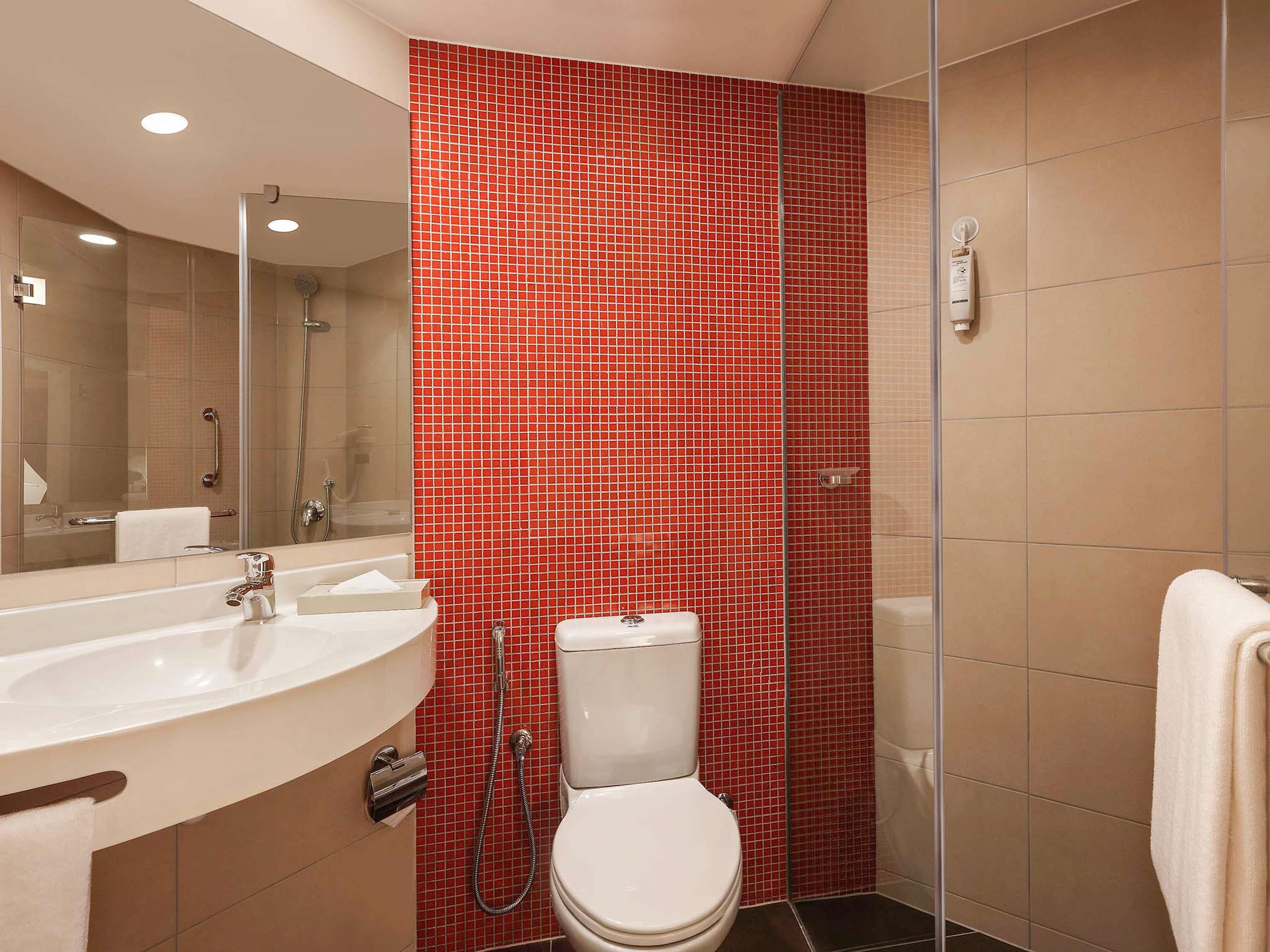 A bathroom with a white sink, a toilet, and a shower area.