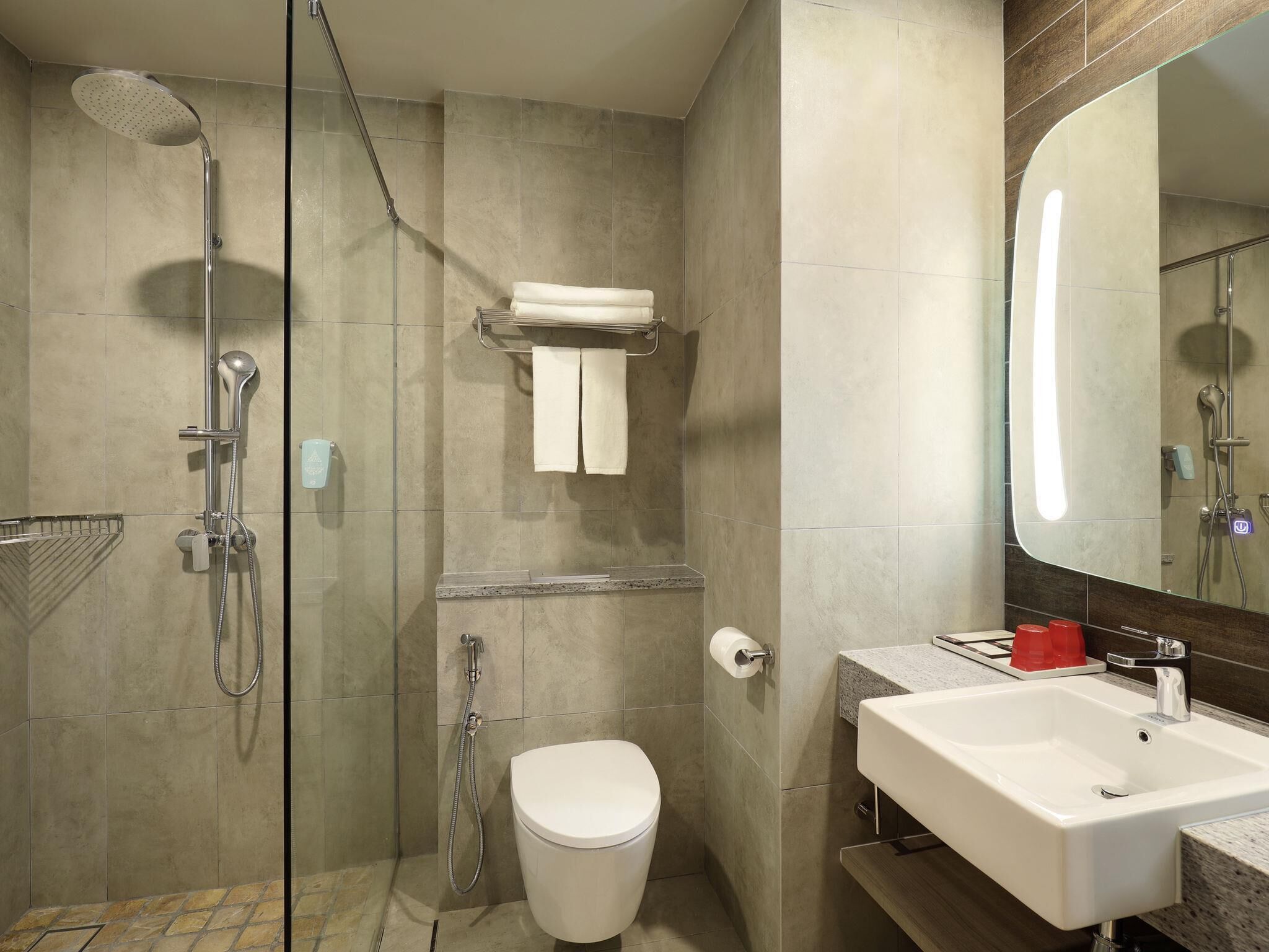 Une salle de bain moderne équipée d’une douche, de toilettes et d’un lavabo.