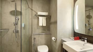 A modern bathroom with a shower, toilet, and sink.