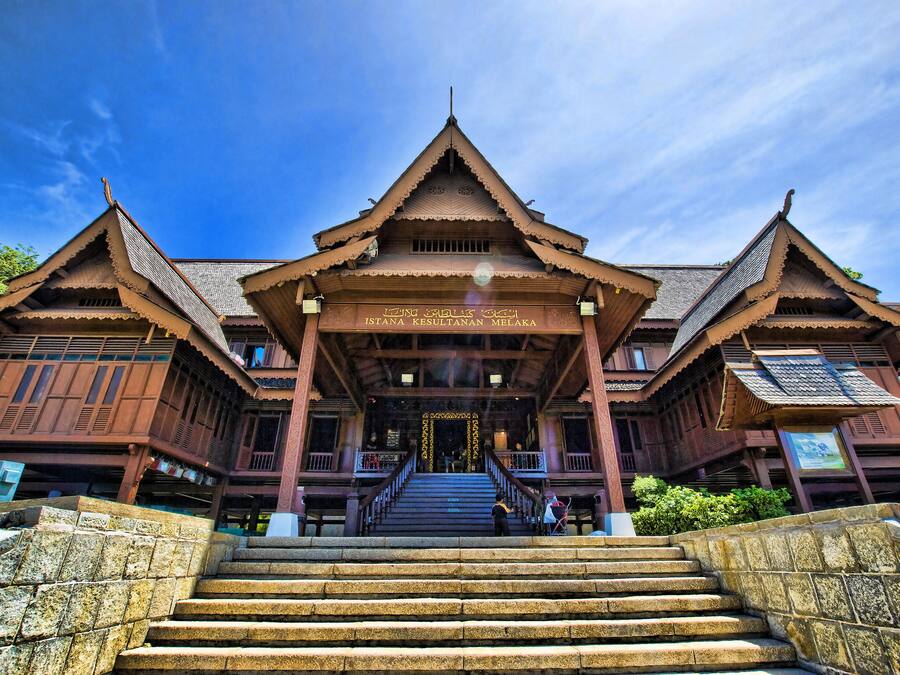 A traditional wooden building with a central staircase leading to a covered entrance.