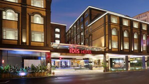 A hotel with a prominent "ibis HOTEL" sign, multiple floors, and a well-lit entrance. - ibis Melaka (Malacca City)
