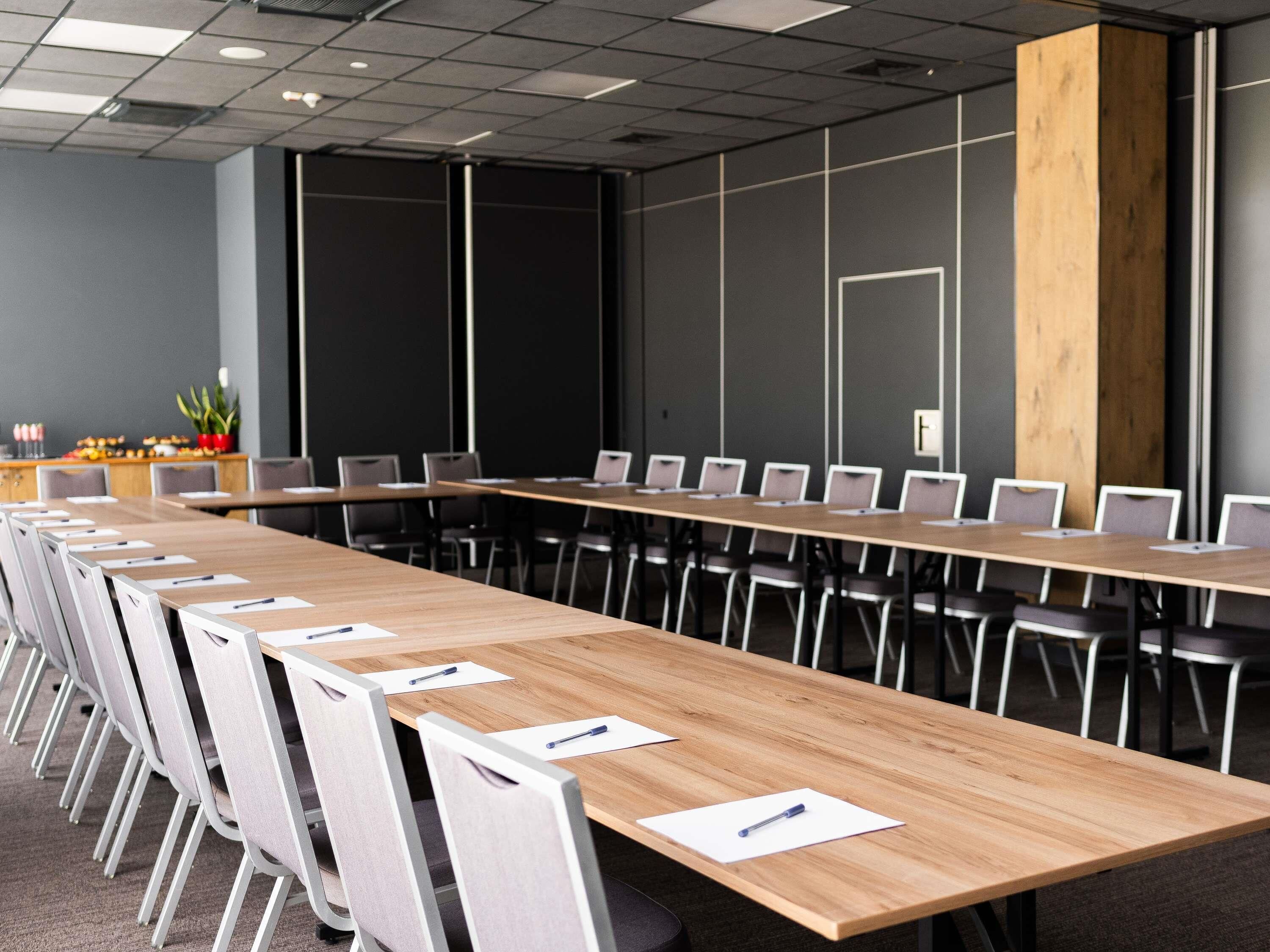 A conference room with a long table, chairs, and a blackboard wall.