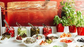 A buffet table with various food items and condiments.