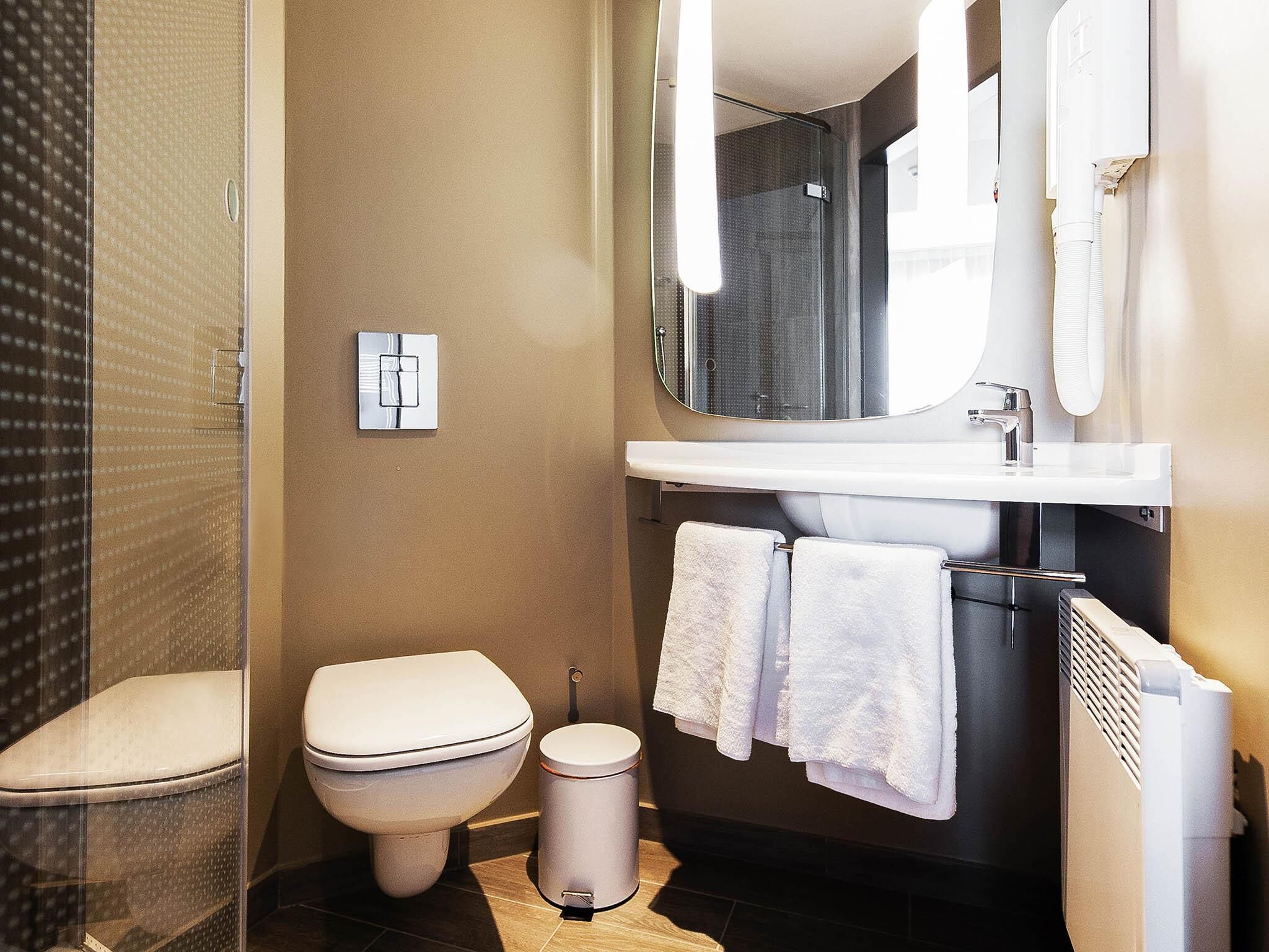 A bathroom with a toilet, sink, and shower.