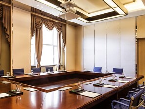 A conference room with a long table, chairs, and a projector. - Novotel Daqing Haofang (Daqing)