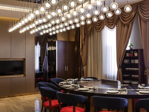 A modern dining area with a round table set for six, surrounded by chairs.