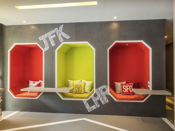 Una pared con tres zonas de estar hexagonales, cada una de diferente color y con nombres de ciudades.