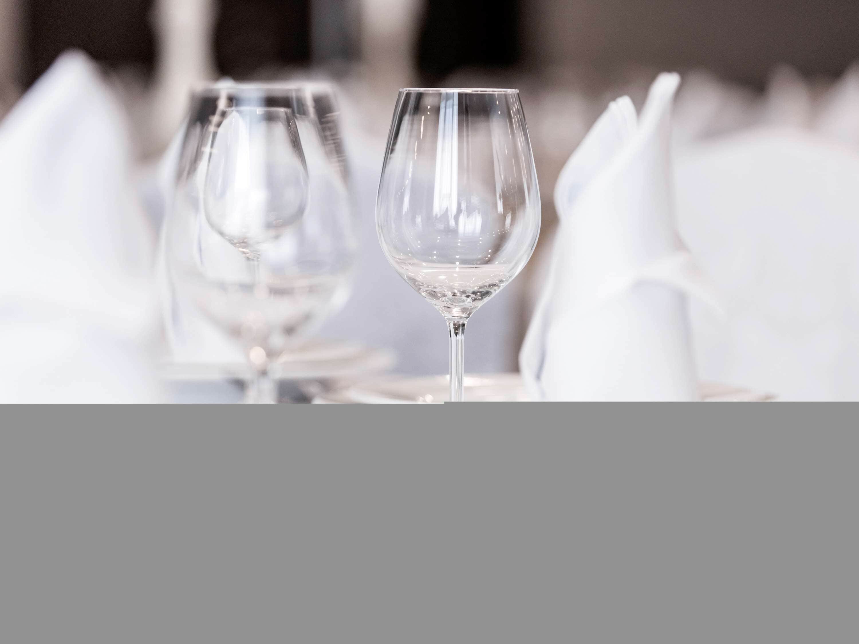 Two empty wine glasses on a table with white napkins.