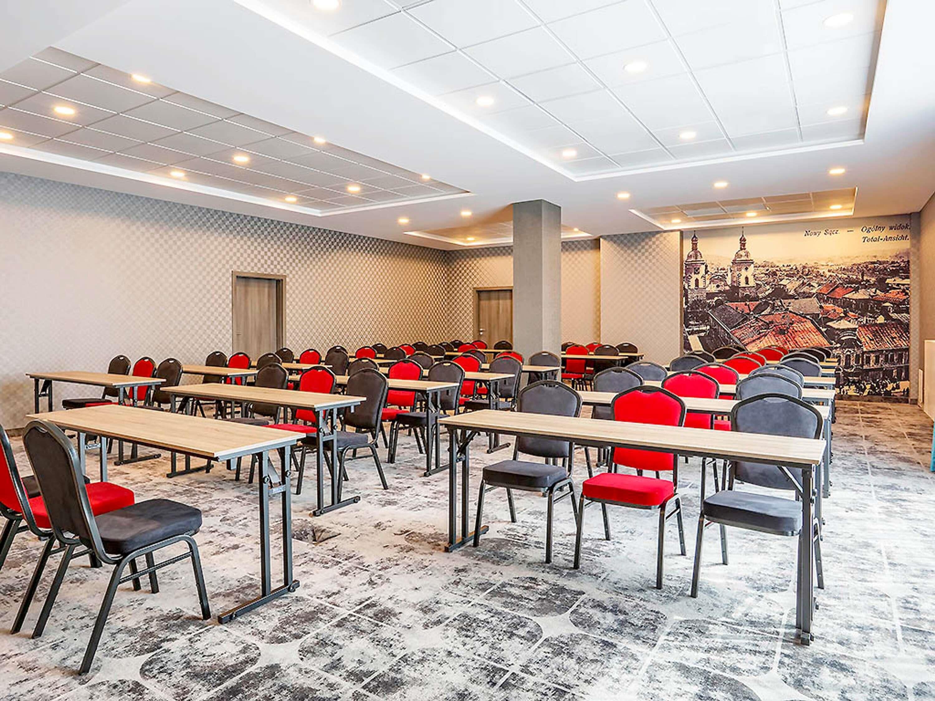 A conference room with tables and chairs, a patterned carpet, and a cityscape mural on the wall.